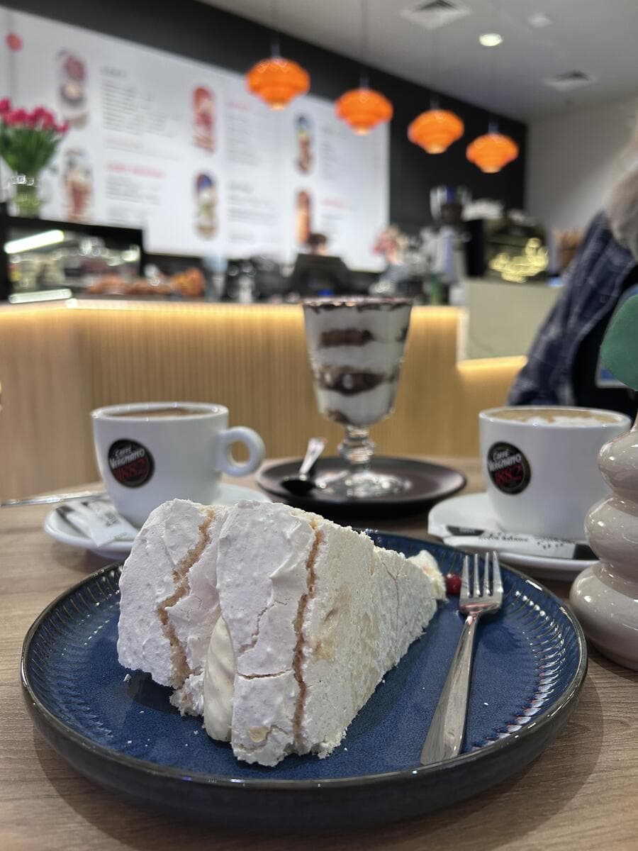 Meringue cake and coffee in a cosy café