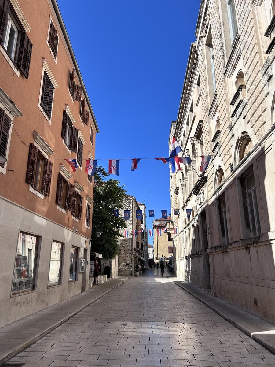 Croatian old town street with flags stretching overhead