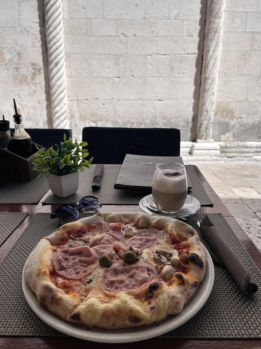 Pizza beside ancient stone columns in Croatia