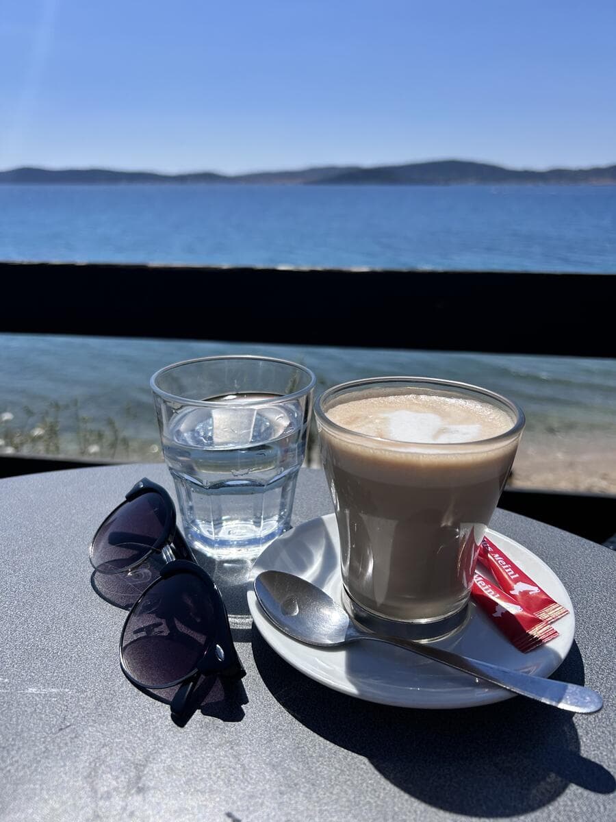 Latte macchiato with sunglasses next to the Adriatic
