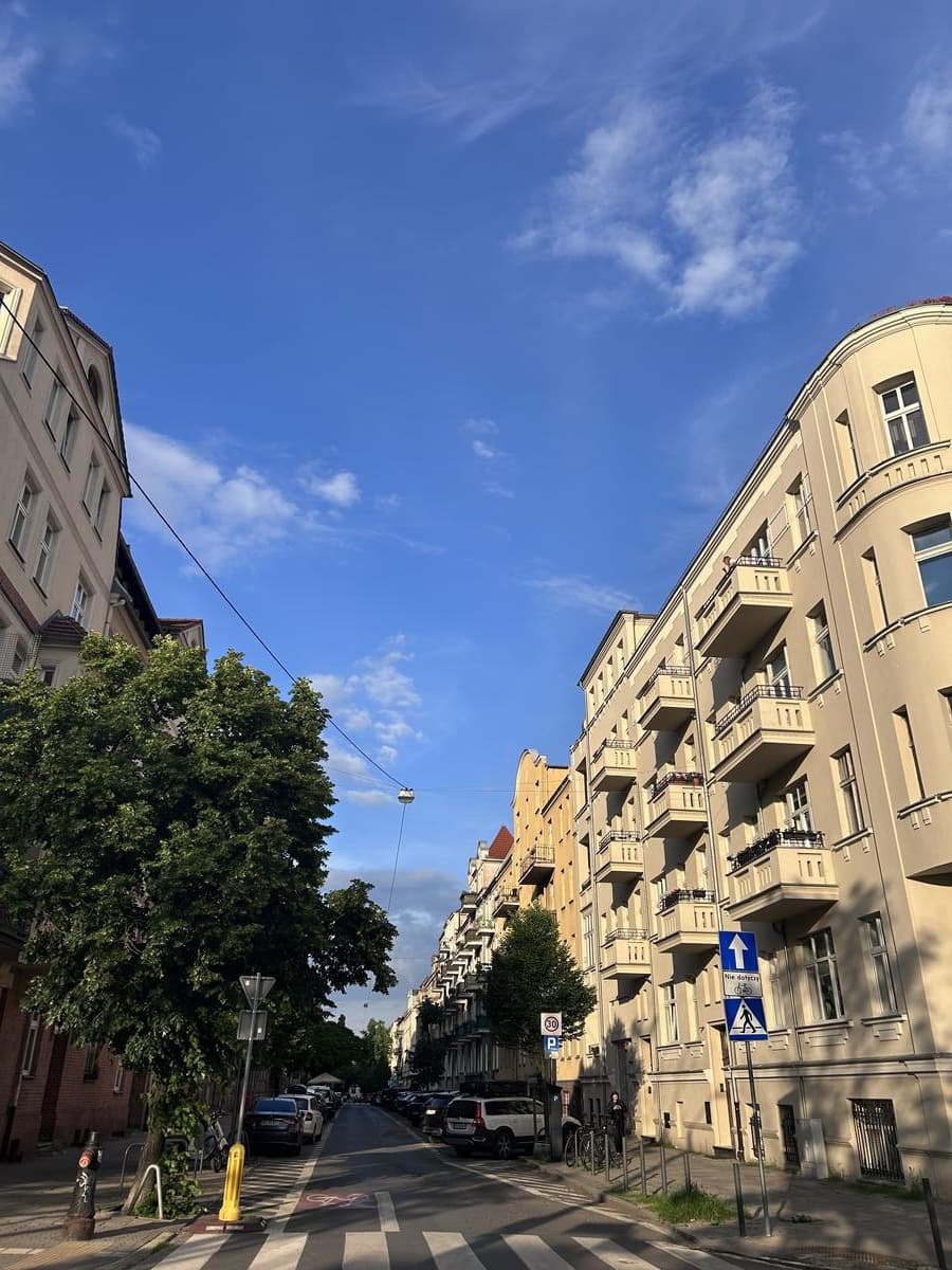 Sunny Poznań street flanked by elegant buildings